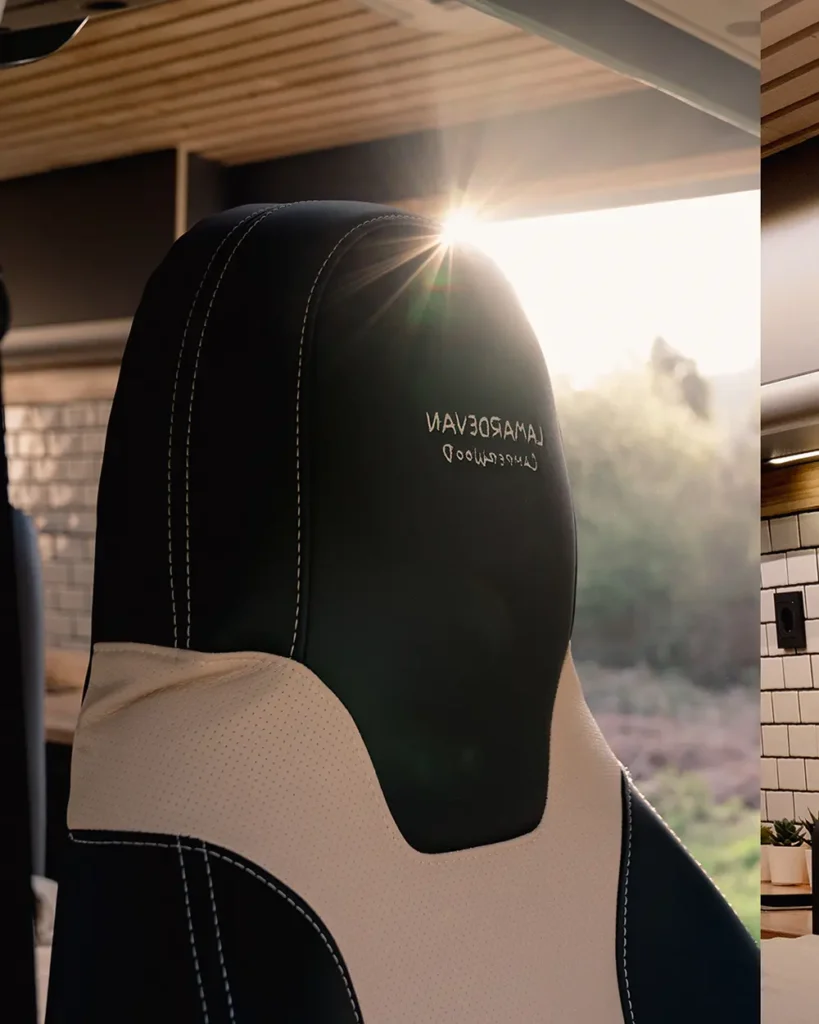 Detalles del asiento del conductor en la Fiat Ducato, destacando el logo de "Lamardevan Camperwood" bordado en la parte superior del respaldo del asiento, con acabados en cuero blanco y negro.