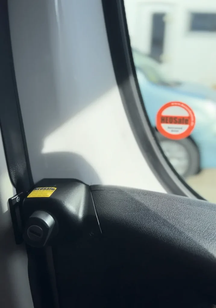 "Ventana lateral de una furgoneta camperizada con un sello de seguridad 'HEOSafe', reflejando un enfoque en la seguridad y privacidad.
